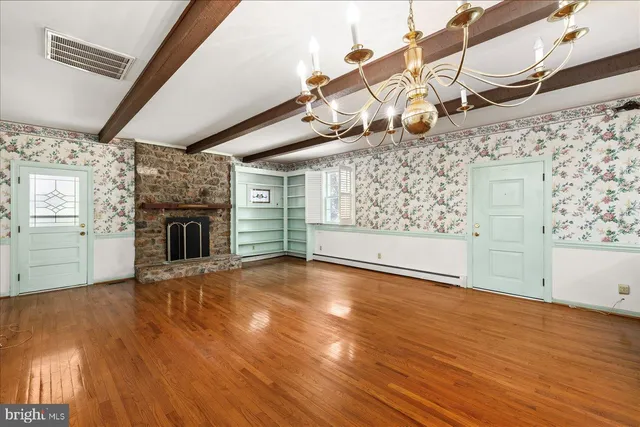 a view of a livingroom with wooden floor and a fireplace