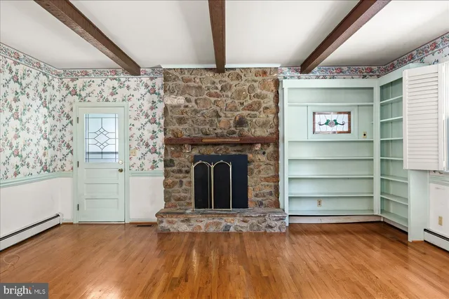 a view of an empty room with a fireplace and a window