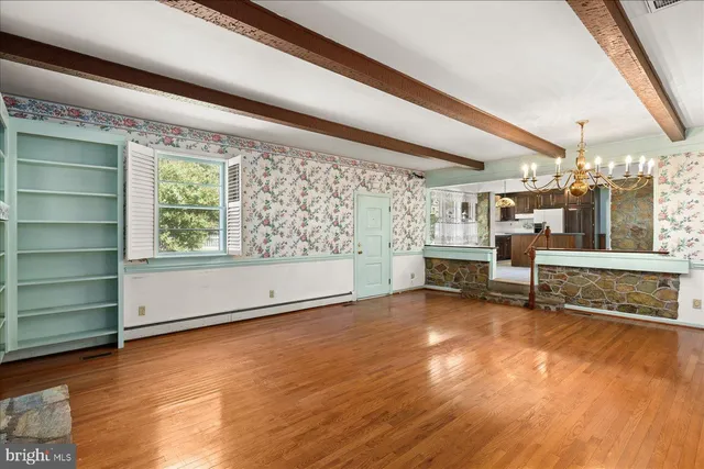 a view of an empty room with a fireplace and a window
