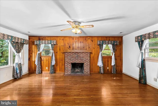 a view of an empty room with a fireplace and a window