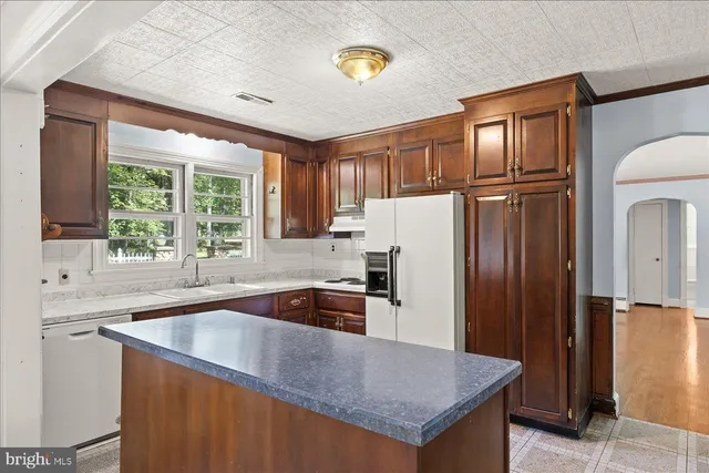 a kitchen with granite countertop a refrigerator and a sink