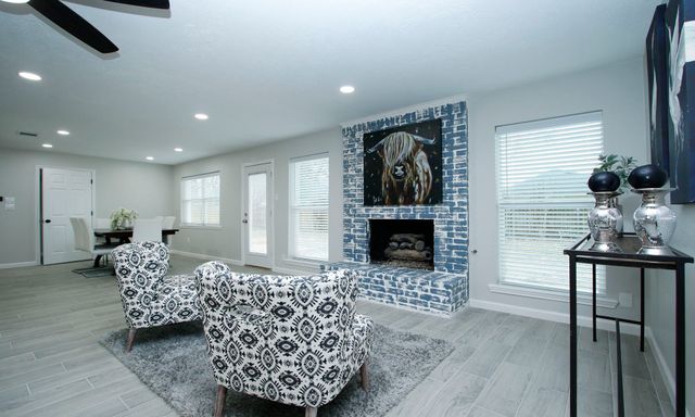 a living room with furniture a fireplace and a flat screen tv