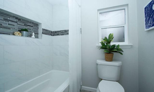 a white toilet sitting next to a bath tub