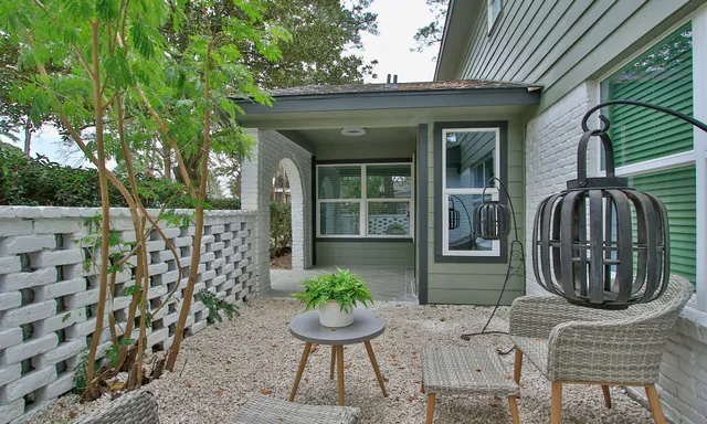 a view of a porch with chairs and potted plants