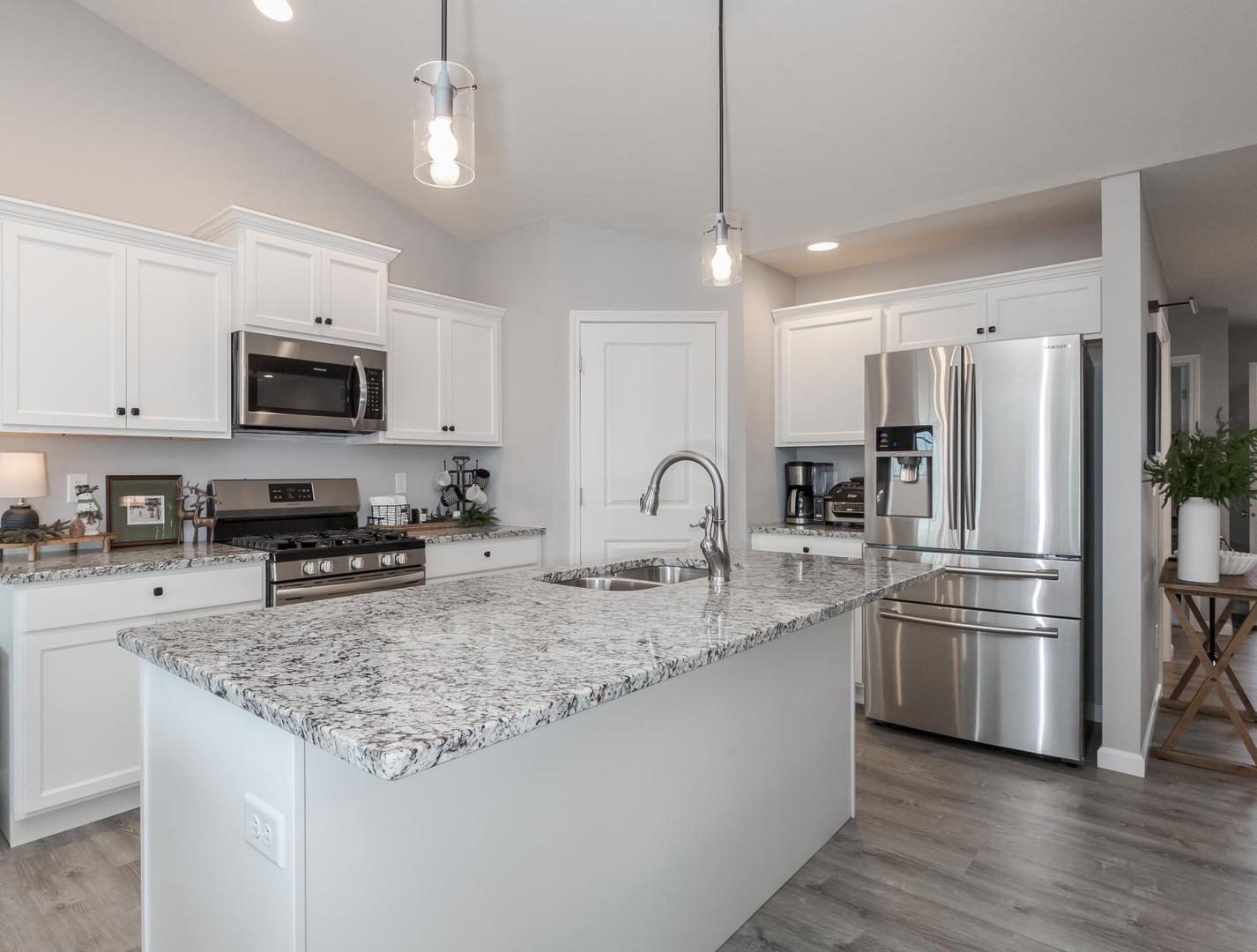 231 Eugene Drive Normal, IL 61761 - Photo 5 of 30 a kitchen with stainless steel appliances granite countertop a refrigerator a stove a sink a microwave a refrigerator and white cabinets with wooden floor