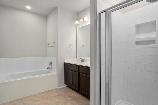a bathroom with a tub double sink and mirror