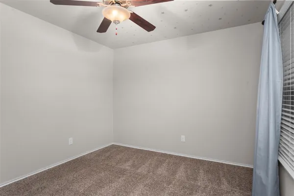 an empty room with a chandelier fan