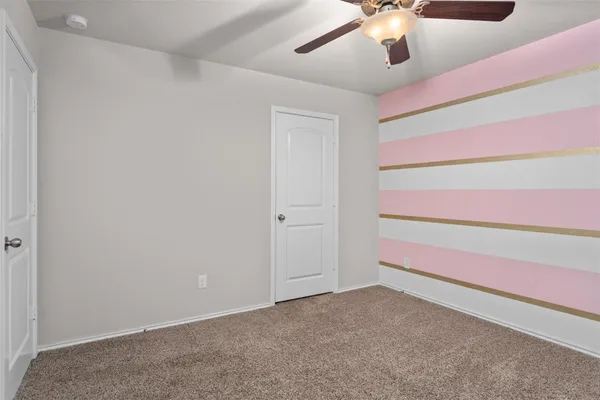 a view of an empty room with a chandelier fan