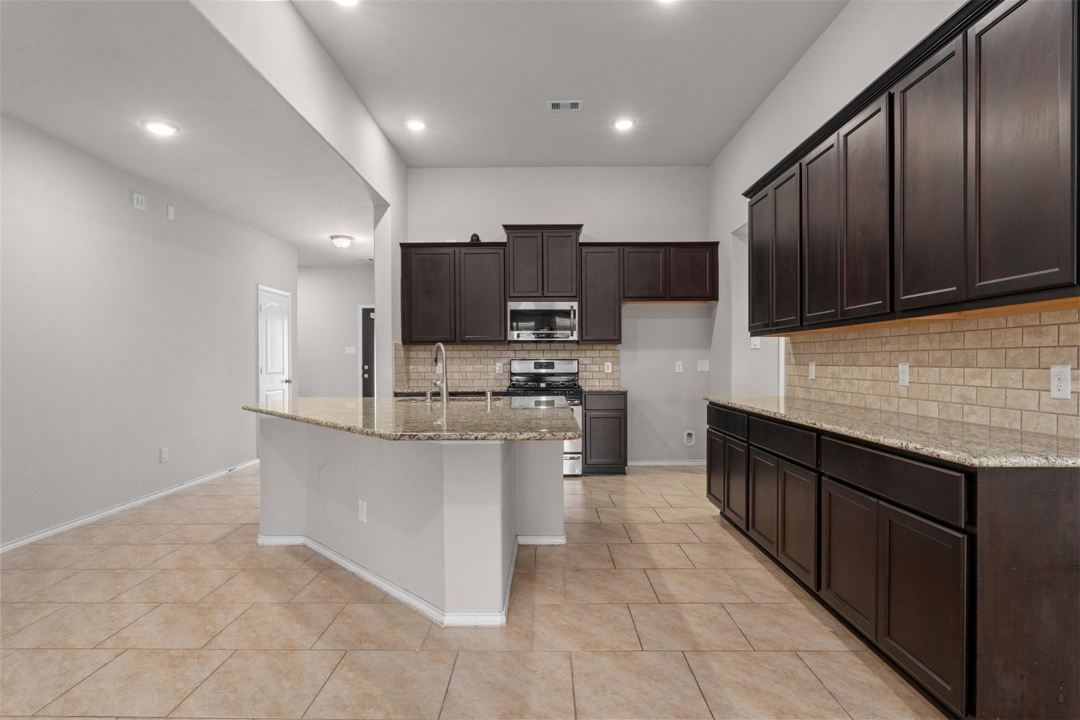 5210 Adria Hills Circle Spring, TX 77389 - Photo 7 of 42 a kitchen with stainless steel appliances granite countertop a stove top oven a sink and a microwave