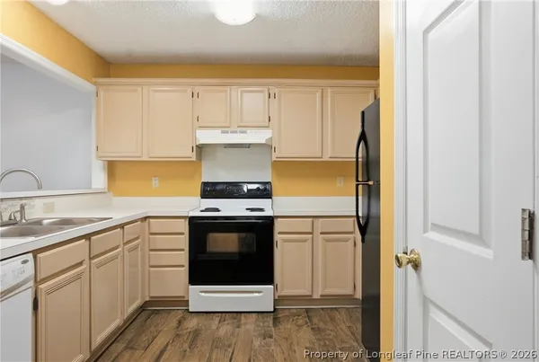 a kitchen with stainless steel appliances a refrigerator sink and white cabinets