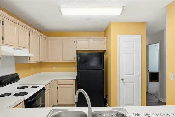 a kitchen with a refrigerator and cabinets