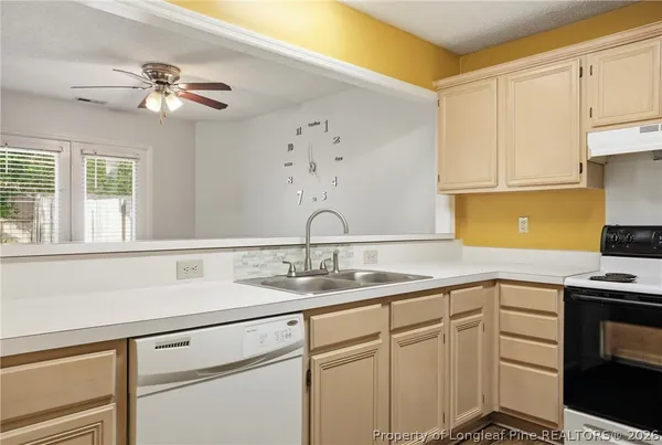 a view with cabinets a sink and appliances