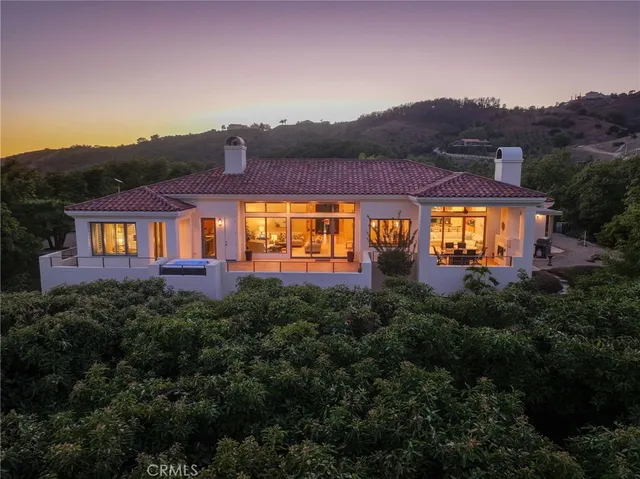 a view of a big house with a big yard and large trees