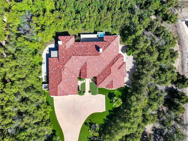 an aerial view of a house with a yard and trees