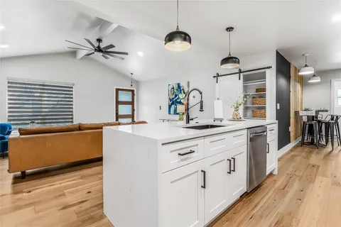 a kitchen with kitchen island a counter top space wooden floor and a ceiling fan