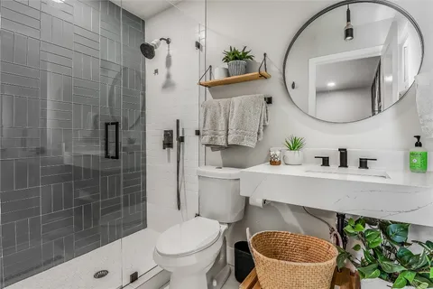 a bathroom with a sink a toilet and a mirror