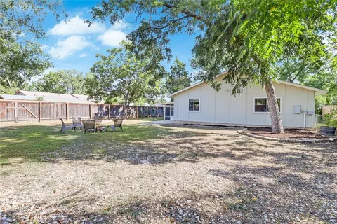 a view of a house with backyard and a tree
