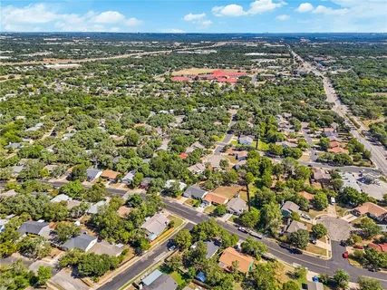 an aerial view of residential houses with outdoor space and trees