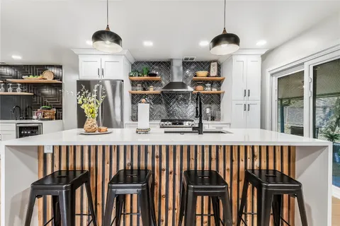 a view of a hallway with kitchen view and dining table