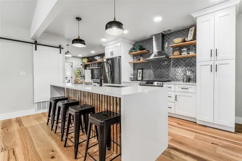 a kitchen with kitchen island white cabinets and stainless steel appliances