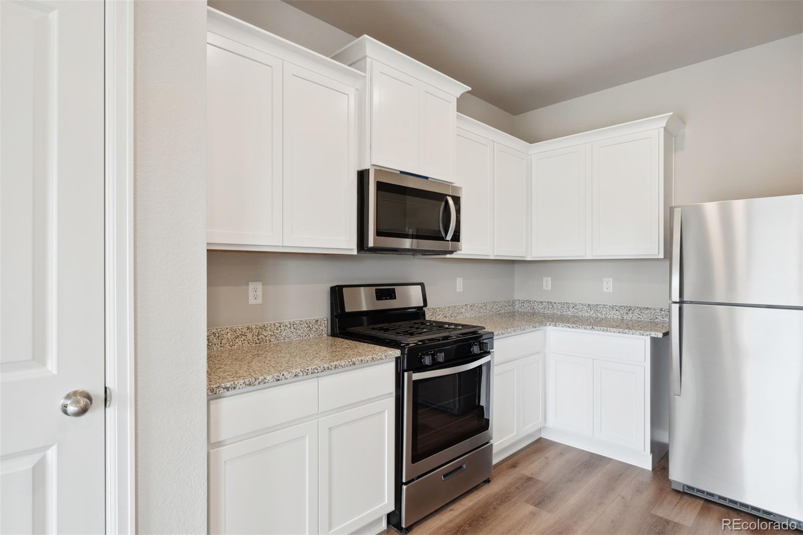 977 Ouzel Falls Road Severance, CO 80550 - Photo 3 of 19 a kitchen with a stove microwave and refrigerator
