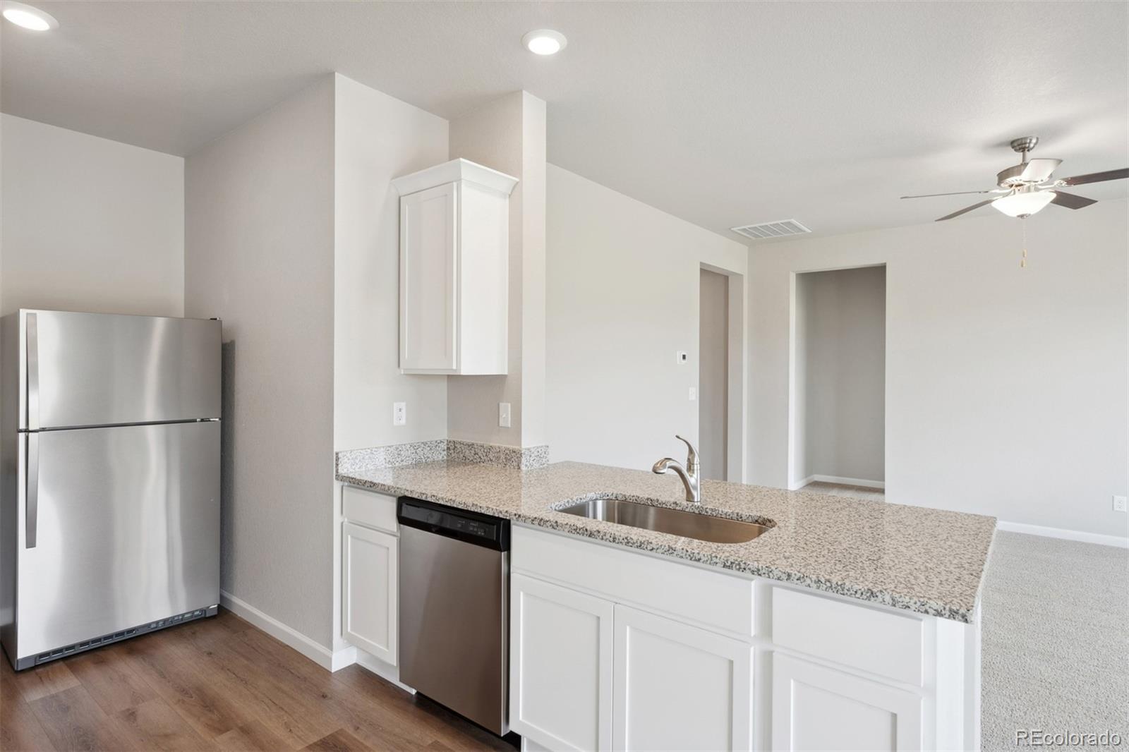 977 Ouzel Falls Road Severance, CO 80550 - Photo 4 of 19 a kitchen with a sink cabinets and stainless steel appliances