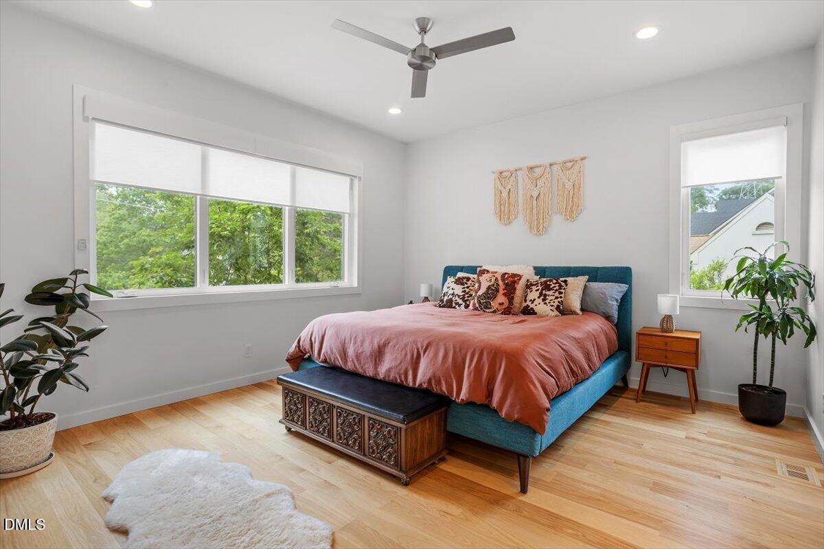 1410 Duplin Road Raleigh, NC 27607 - Photo 23 of 54 a spacious bedroom with a bed and a potted plant