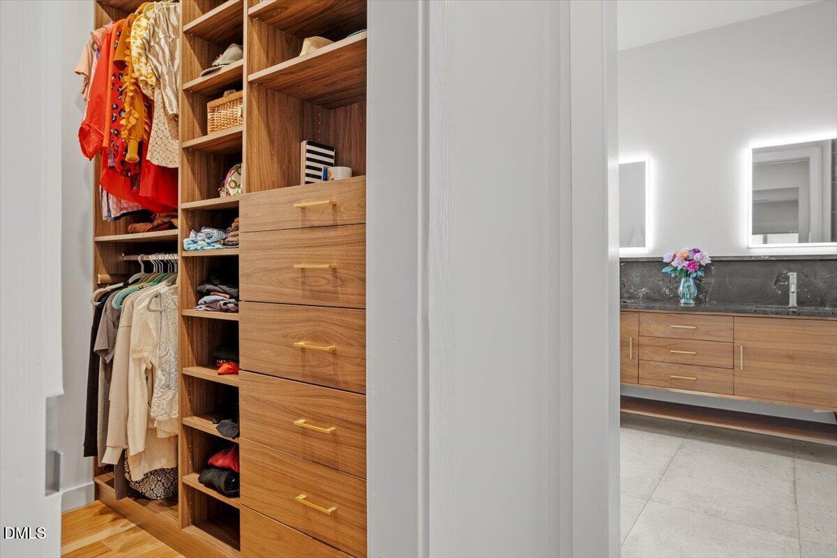 1410 Duplin Road Raleigh, NC 27607 - Photo 24 of 54 a view of walk in closet with clothes and shoes