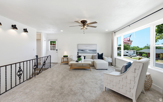 120 North 1230 E Street Springville, UT 84663 - Photo 8 of 60 Spacious living area featuring light-toned carpet, a ceiling fan with integrated lighting, and multiple windows
