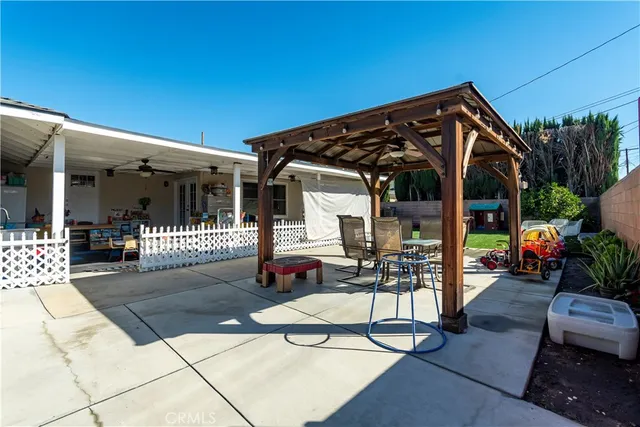a view of a backyard with potted plants and large tree