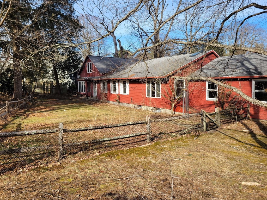 128 Amherst Road Pelham, MA 01002 - Photo 1 of 31 a view of a white house with a yard and lawn chairs under an umbrella