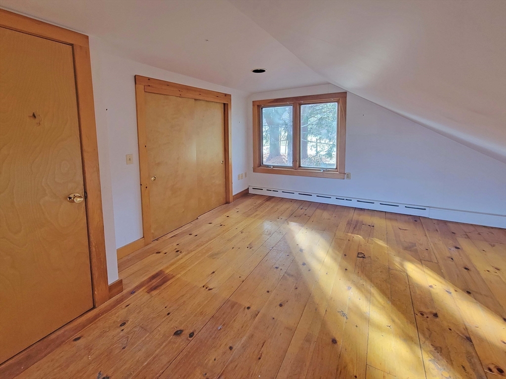 128 Amherst Road Pelham, MA 01002 - Photo 22 of 31 a view of an empty room with a window and wooden floor