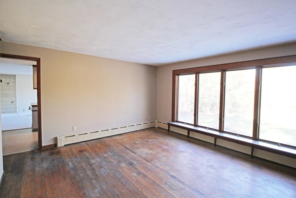 128 Amherst Road Pelham, MA 01002 - Photo 4 of 31 an empty room with wooden floor and windows