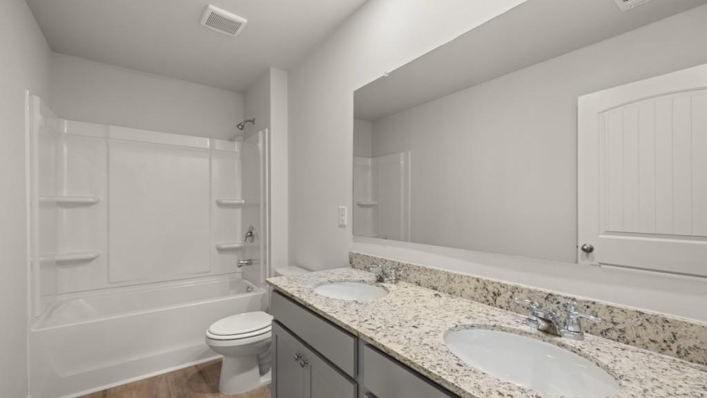 92 Cyrilla Walk Dallas, GA 30132 - Photo 27 of 35 a bathroom with a granite countertop sink a toilet and bathtub