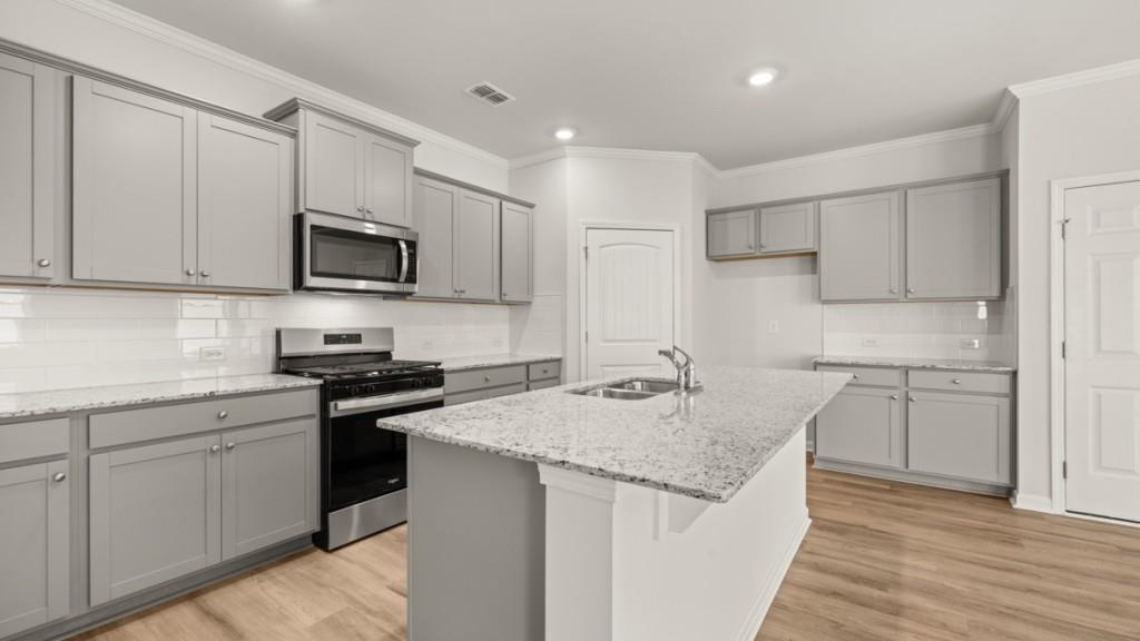 92 Cyrilla Walk Dallas, GA 30132 - Photo 5 of 35 a kitchen with stainless steel appliances granite countertop a sink stove microwave and refrigerator