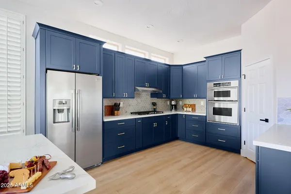 a kitchen with granite countertop a refrigerator and a stove top oven