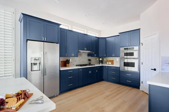 a kitchen with granite countertop a refrigerator and a stove top oven