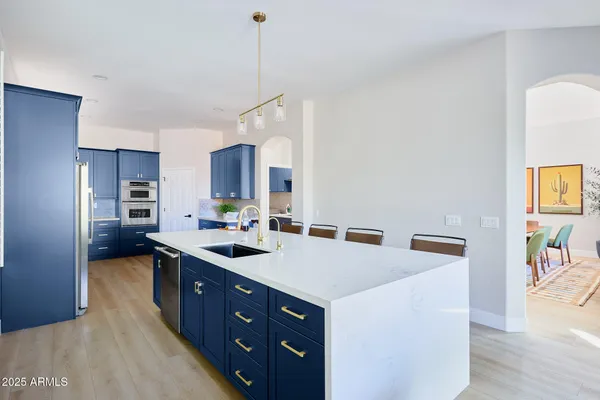 a kitchen with a sink a stove a refrigerator and chairs