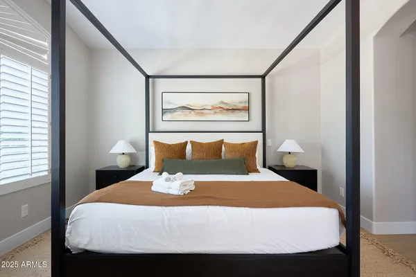 a bed sitting in a bedroom next to a window