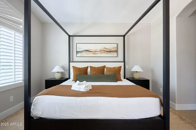 a bed sitting in a bedroom next to a window