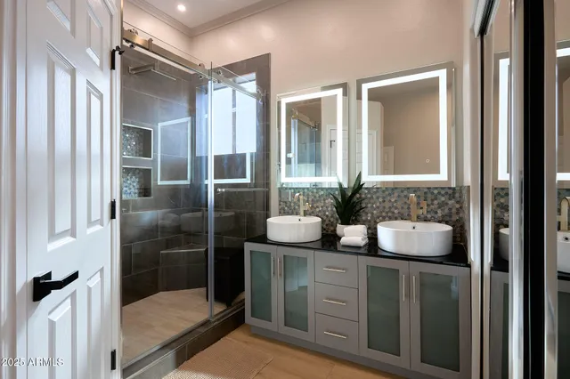 a bathroom with a granite countertop sink a large mirror and a shower