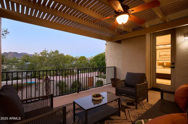a balcony with wooden floor and outdoor seating