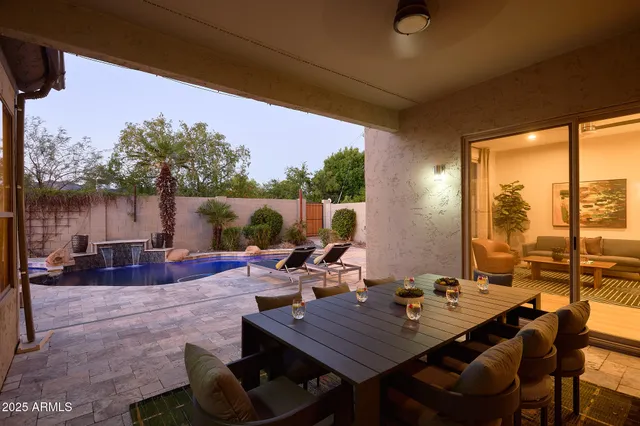 a view of a patio with couches and table and chairs with wooden floor and fence