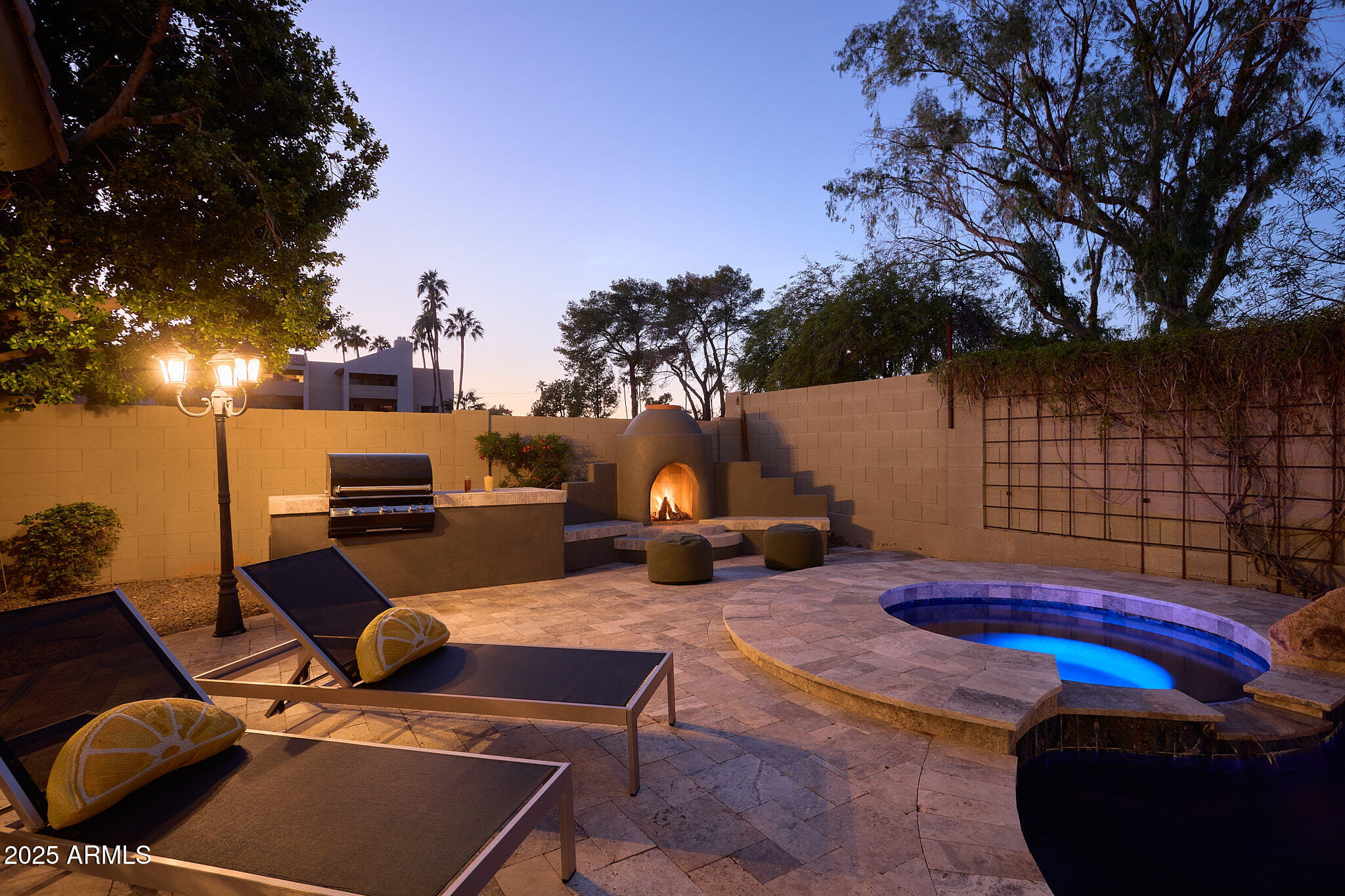 3202 East Orange Drive Phoenix, AZ 85018 - Photo 49 of 52 a view of a backyard with couches table and chairs under an umbrella with a fire pit