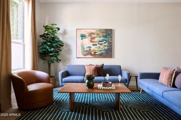 a living room with furniture plant and a window
