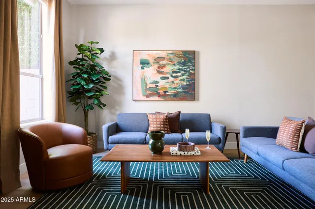 a living room with furniture plant and a window