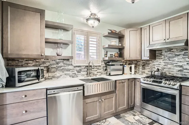a kitchen with stainless steel appliances granite countertop a stove sink and cabinets
