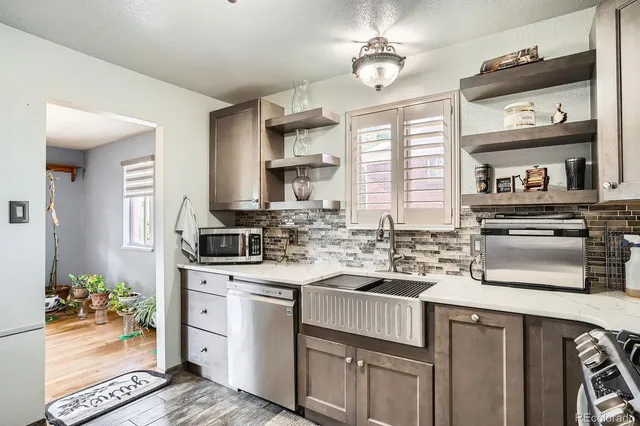 a kitchen with kitchen island granite countertop a sink cabinets stainless steel appliances and a counter top space