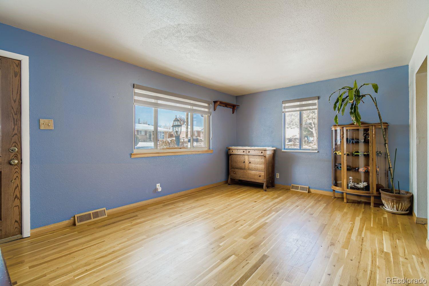 8510 Faraday Street Denver, CO 80229 - Photo 7 of 25 a view of an empty room with a window and wooden floor
