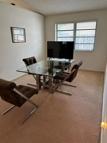 a view of a livingroom with workspace and a window